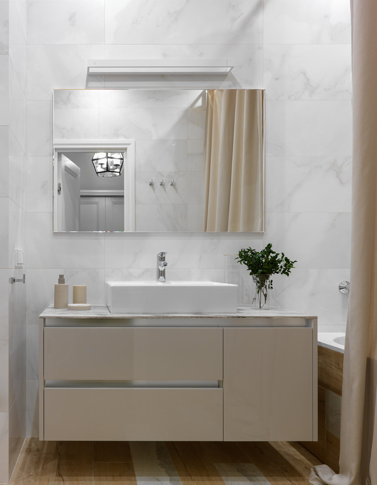 Bild på ett mellanstort funkis en-suite badrum, med släta luckor, beige skåp, porslinskakel, klinkergolv i porslin, ett badkar i en alkov och ett fristående handfat