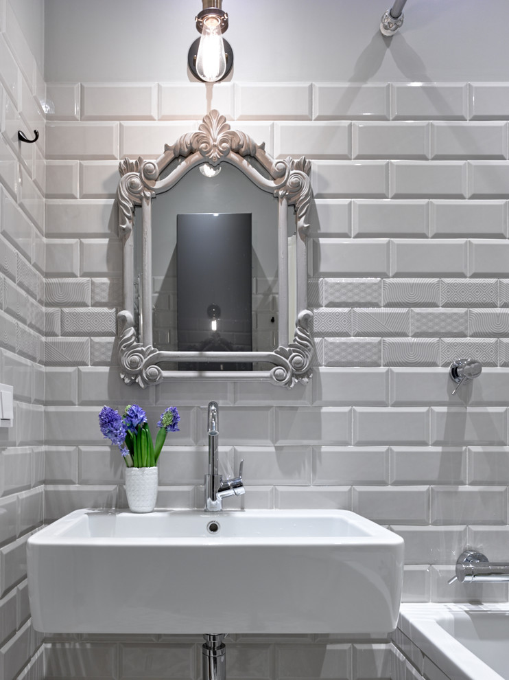 Inredning av ett klassiskt badrum, med vit kakel, tunnelbanekakel, vita väggar och ett väggmonterat handfat