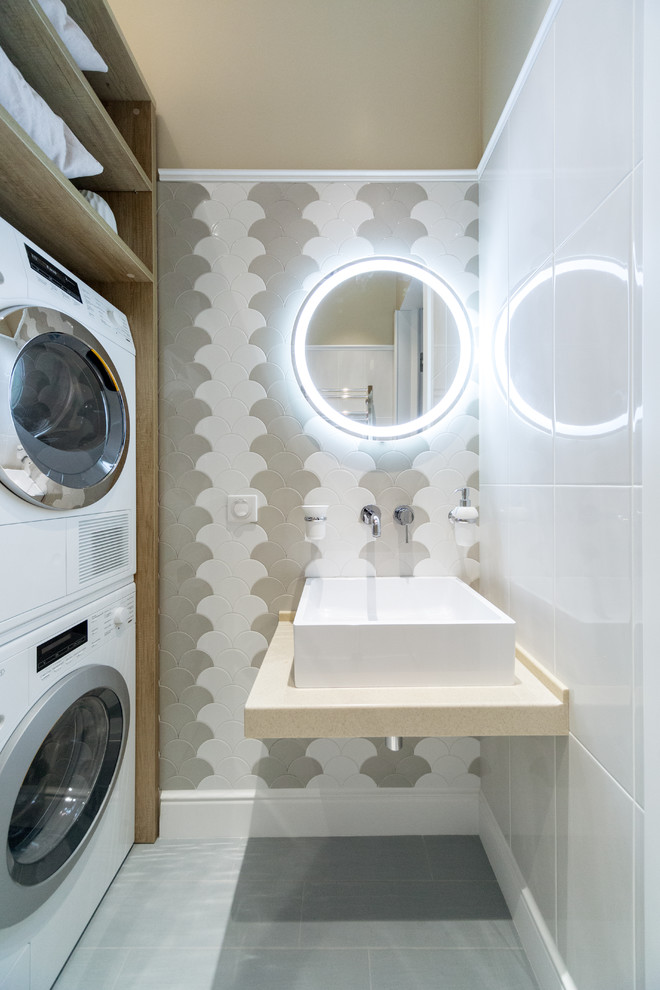 На фото: ванная комната в скандинавском стиле с белой плиткой, серой плиткой, душевой кабиной, настольной раковиной и серым полом с