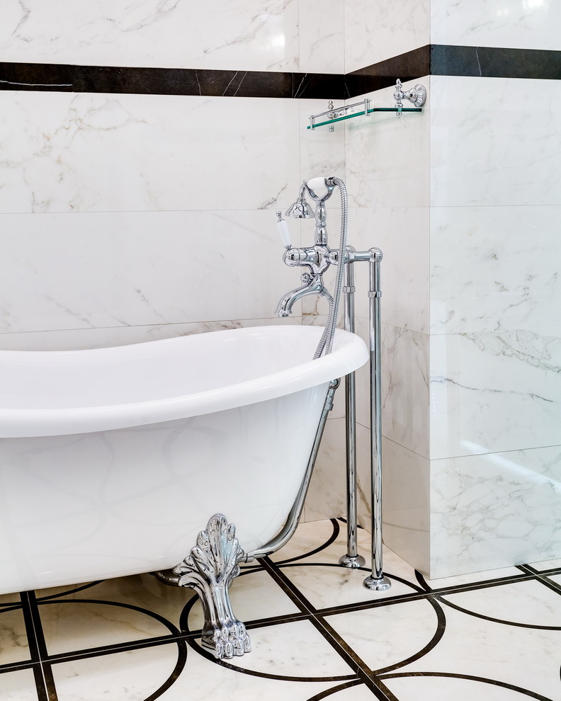 На фото: главная ванная комната в классическом стиле с ванной на ножках и белой плиткой