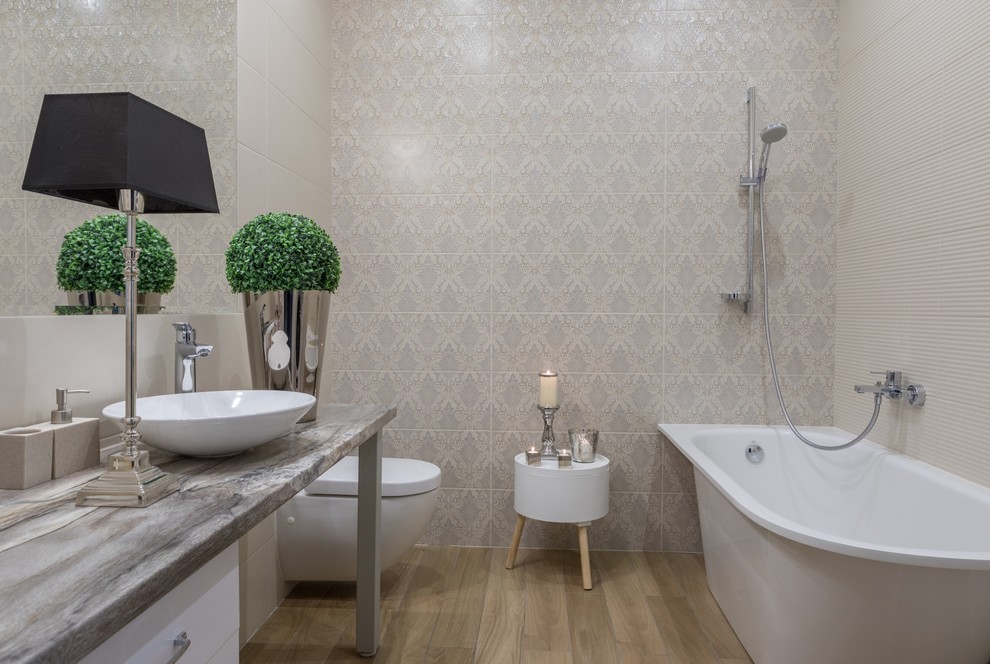 Contemporary ensuite bathroom in Other with a wall mounted toilet, beige tiles and a vessel sink.