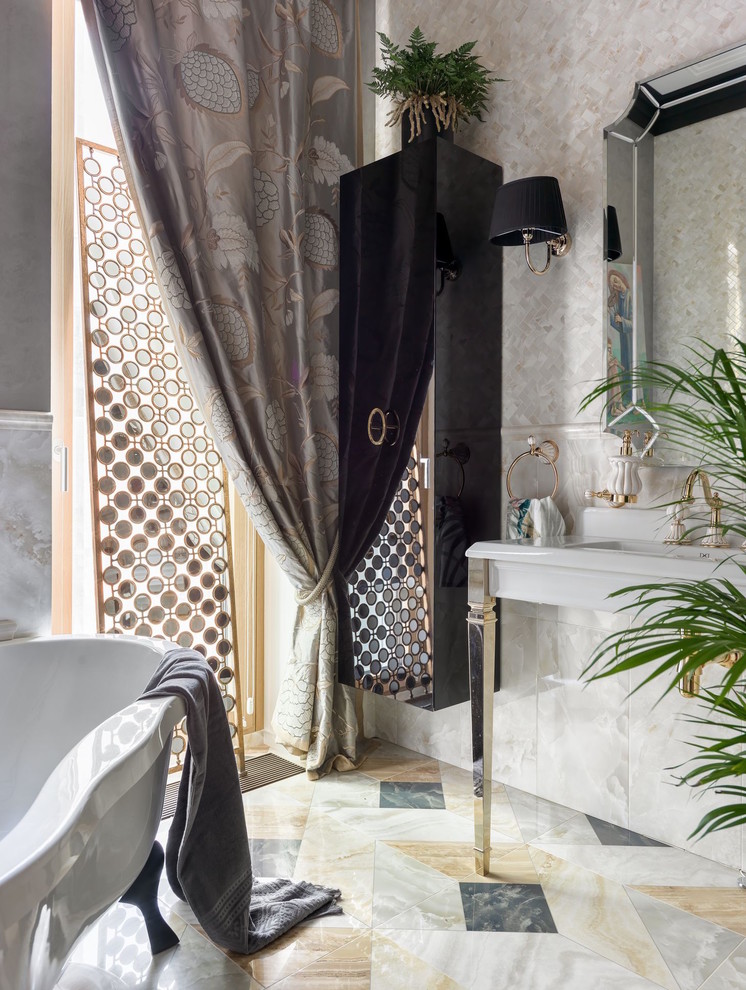 Стильный дизайн: главная ванная комната в стиле неоклассика (современная классика) с ванной на ножках, бежевой плиткой, консольной раковиной и разноцветным полом - последний тренд