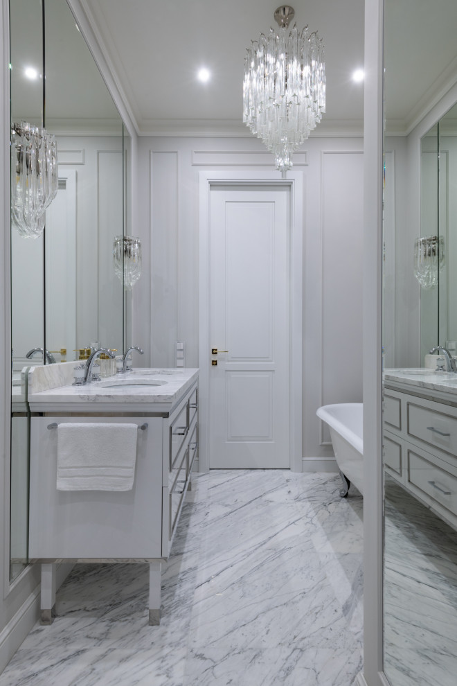 Aménagement d'une salle de bain classique de taille moyenne avec un placard à porte affleurante, des portes de placard blanches, une baignoire indépendante, WC suspendus, un carrelage gris, des carreaux de porcelaine, un mur gris, un sol en marbre, un lavabo encastré, un plan de toilette en marbre, un sol blanc, une cabine de douche à porte battante, un plan de toilette blanc, une niche, meuble double vasque et meuble-lavabo sur pied.