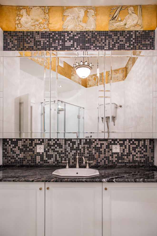 Стильный дизайн: ванная комната в классическом стиле с белыми фасадами, черной плиткой и накладной раковиной - последний тренд