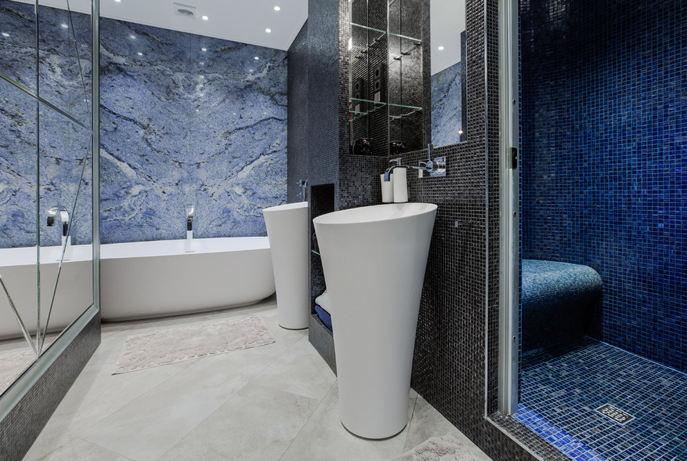 Modern inredning av ett badrum, med ett fristående badkar, svart kakel, blå kakel, vit kakel, mosaik, klinkergolv i keramik, ett konsol handfat och flerfärgade väggar