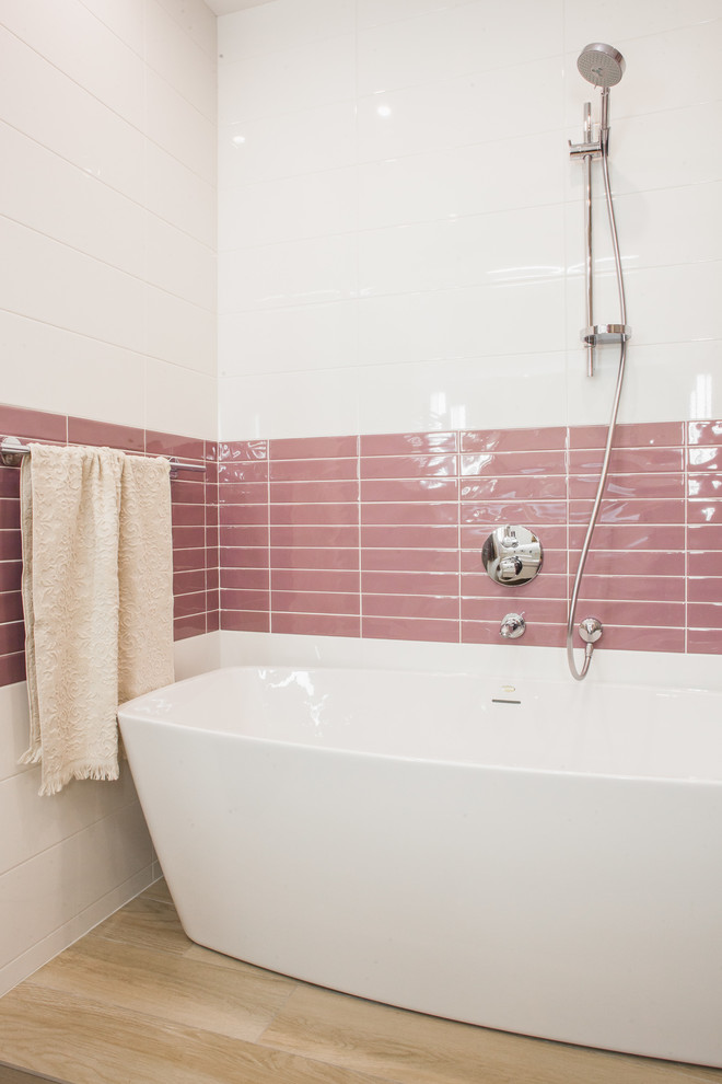 На фото: главная ванная комната среднего размера в современном стиле с отдельно стоящей ванной, керамической плиткой, полом из керамогранита, белой плиткой и розовой плиткой