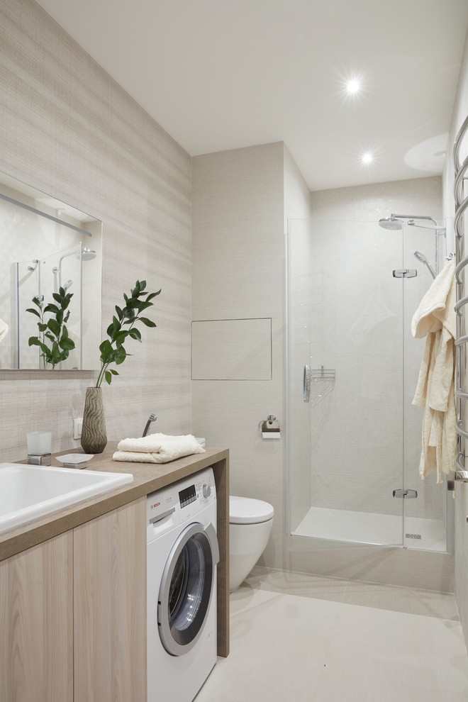 Пример оригинального дизайна: ванная комната в современном стиле с плоскими фасадами, светлыми деревянными фасадами, душем в нише, раздельным унитазом, белой плиткой, душевой кабиной, накладной раковиной, белым полом, душем с распашными дверями и бежевой столешницей
