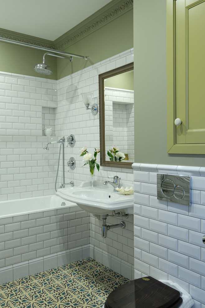 Modelo de cuarto de baño principal tradicional con bañera empotrada, combinación de ducha y bañera, baldosas y/o azulejos blancos, baldosas y/o azulejos de cemento, paredes verdes, lavabo suspendido, ducha con cortina, sanitario de una pieza y suelo multicolor