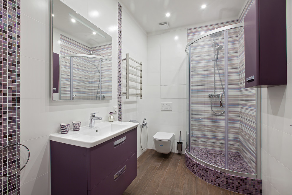 Cette photo montre une salle d'eau tendance de taille moyenne avec un placard à porte plane, des portes de placard violettes, une baignoire indépendante, une douche d'angle, un carrelage blanc, des carreaux de porcelaine, un sol en carrelage de porcelaine, un lavabo suspendu, un plan de toilette en surface solide, un sol marron et une cabine de douche à porte coulissante.