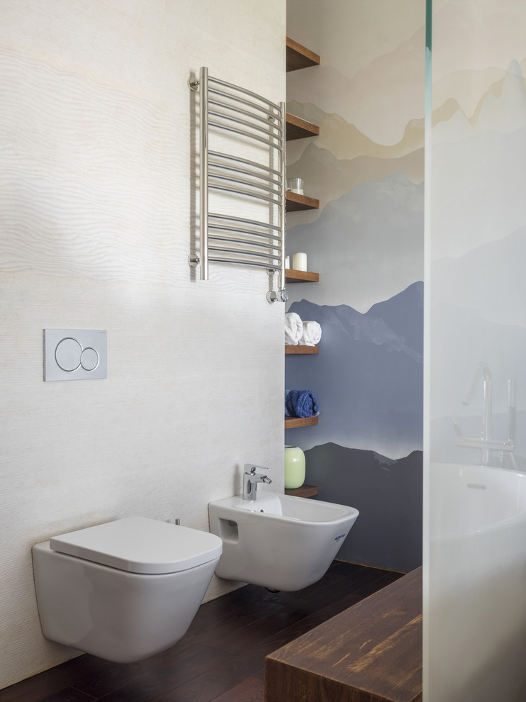 Ispirazione per una stanza da bagno design di medie dimensioni con WC sospeso, piastrelle in gres porcellanato, pareti beige, pavimento in legno verniciato e pavimento marrone
