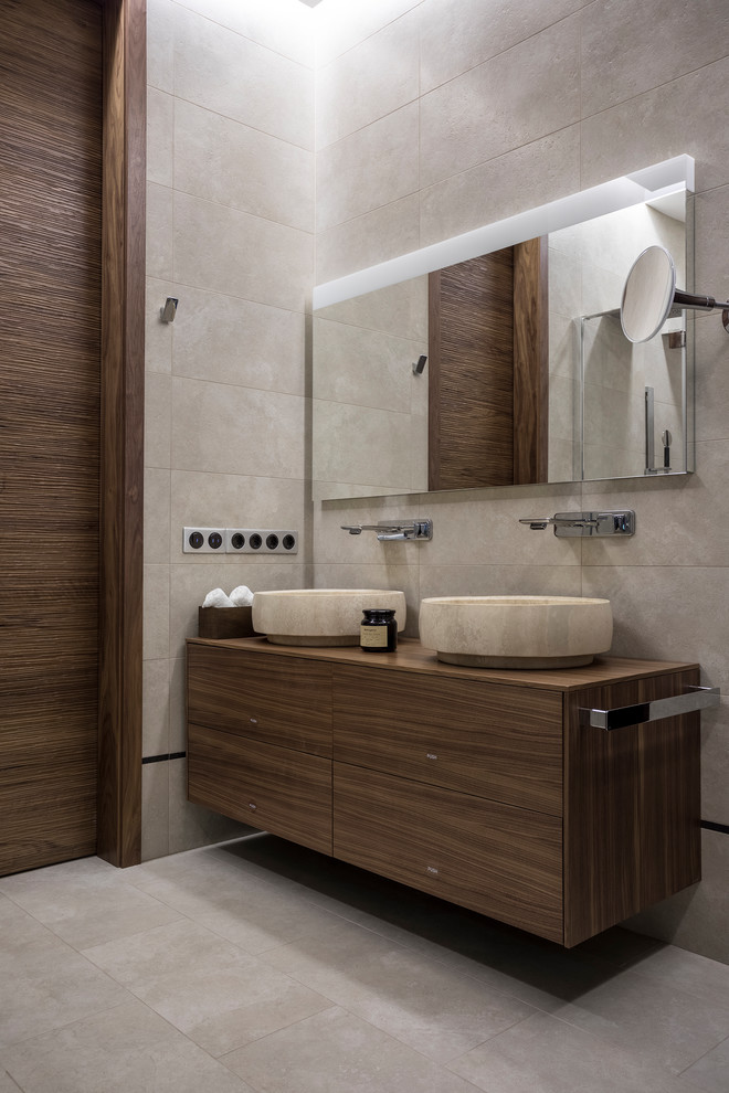 Foto på ett mellanstort funkis brun badrum, med släta luckor, beige kakel, travertinkakel, travertin golv, träbänkskiva, beiget golv, skåp i mellenmörkt trä och ett fristående handfat