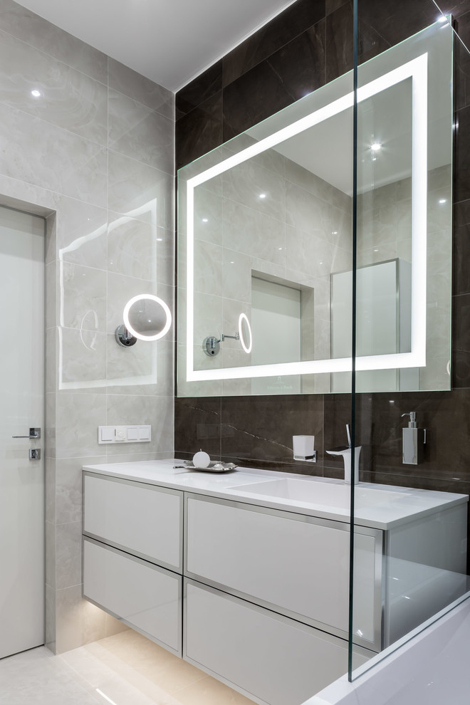 Exempel på ett mellanstort modernt vit vitt en-suite badrum, med luckor med glaspanel, vita skåp, ett platsbyggt badkar, en dusch/badkar-kombination, en vägghängd toalettstol, beige kakel, keramikplattor, beige väggar, klinkergolv i porslin, ett integrerad handfat, bänkskiva i kvarts, beiget golv och dusch med duschdraperi