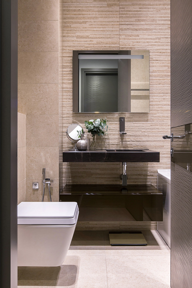 Стильный дизайн: главная ванная комната в современном стиле с плоскими фасадами, черными фасадами, инсталляцией, бежевой плиткой, монолитной раковиной, бежевым полом, черной столешницей, ванной в нише и бежевыми стенами - последний тренд