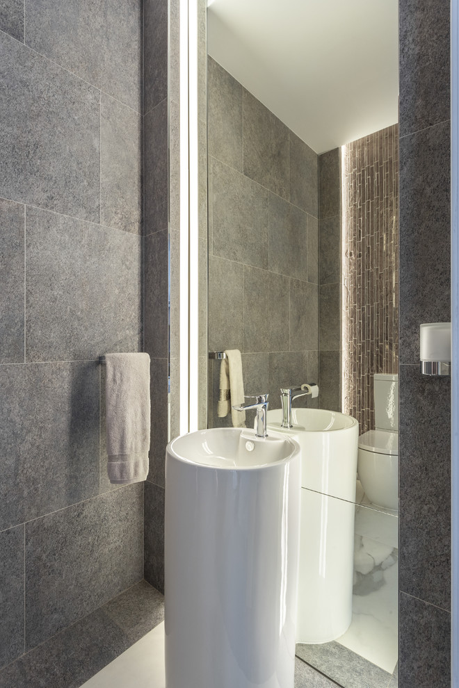 Ejemplo de cuarto de baño contemporáneo pequeño con baldosas y/o azulejos grises, baldosas y/o azulejos de porcelana, suelo de baldosas de porcelana, lavabo con pedestal y suelo blanco