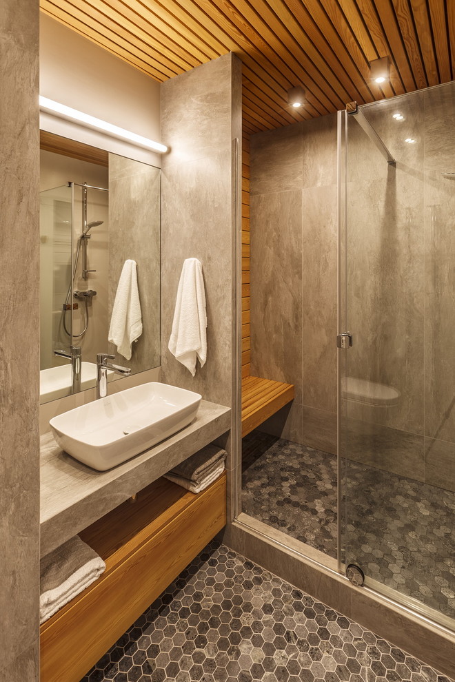 Ejemplo de cuarto de baño contemporáneo con armarios con paneles lisos, puertas de armario de madera oscura, ducha empotrada, baldosas y/o azulejos grises, aseo y ducha, lavabo sobreencimera, suelo gris y encimeras grises