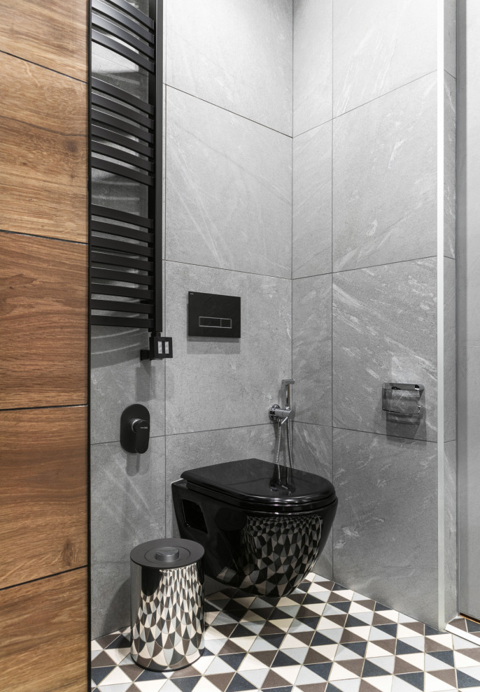 На фото: ванная комната среднего размера в современном стиле с плоскими фасадами, фасадами цвета дерева среднего тона, ванной в нише, душем в нише, инсталляцией, черной плиткой, керамогранитной плиткой, серыми стенами, полом из керамогранита, душевой кабиной, настольной раковиной, столешницей из искусственного камня, разноцветным полом, шторкой для ванной, белой столешницей, тумбой под две раковины, подвесной тумбой и гигиеническим душем с