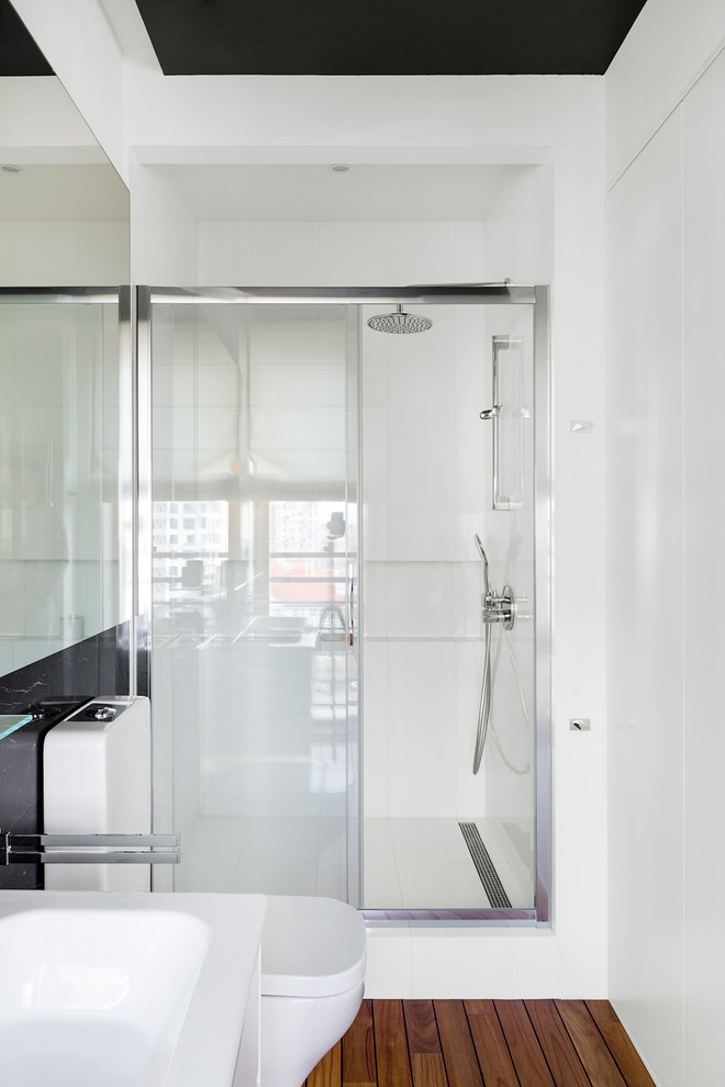 На фото: ванная комната в современном стиле с светлым паркетным полом, душем в нише и душем с раздвижными дверями с