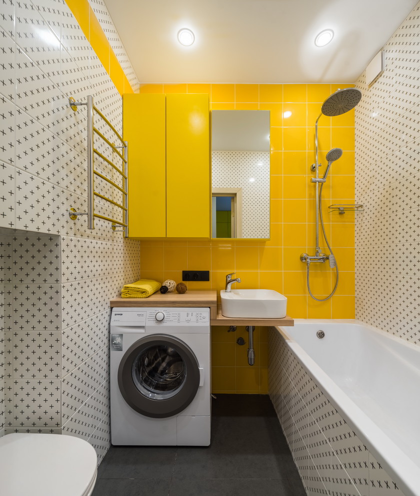 Inspiration för ett funkis brun brunt en-suite badrum, med en dusch/badkar-kombination, en vägghängd toalettstol, vit kakel, gul kakel, ett fristående handfat, träbänkskiva, grått golv, med dusch som är öppen, öppna hyllor och ett badkar i en alkov