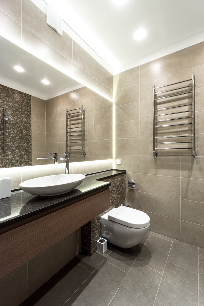 Photo of a medium sized contemporary bathroom in Moscow with flat-panel cabinets, medium wood cabinets, beige tiles, porcelain tiles, porcelain flooring, a vessel sink, solid surface worktops, grey floors, black worktops and a wall mounted toilet.