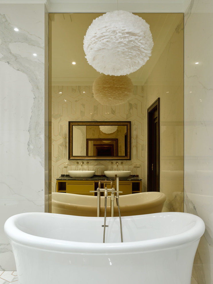 Пример оригинального дизайна: главная ванная комната в стиле неоклассика (современная классика) с отдельно стоящей ванной, плоскими фасадами, бежевыми фасадами, белой плиткой, мраморной плиткой, белыми стенами, полом из мозаичной плитки, мраморной столешницей, белым полом и черной столешницей
