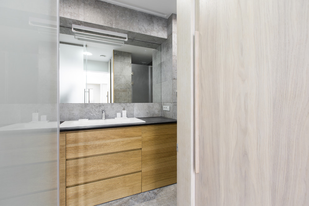 Свежая идея для дизайна: ванная комната среднего размера с душем в нише, инсталляцией, серой плиткой, керамогранитной плиткой, полом из керамогранита, душевой кабиной, накладной раковиной, серым полом и черной столешницей - отличное фото интерьера