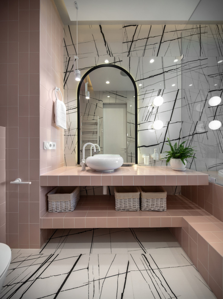 Inspiration för mellanstora rosa en-suite badrum, med öppna hyllor, ett undermonterat badkar, en dusch/badkar-kombination, en vägghängd toalettstol, svart och vit kakel, porslinskakel, vita väggar, klinkergolv i porslin, ett fristående handfat, kaklad bänkskiva, vitt golv och med dusch som är öppen