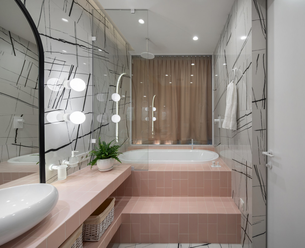Exempel på ett mellanstort rosa rosa en-suite badrum, med öppna hyllor, ett undermonterat badkar, en dusch/badkar-kombination, en vägghängd toalettstol, svart och vit kakel, porslinskakel, vita väggar, klinkergolv i porslin, ett fristående handfat, kaklad bänkskiva, vitt golv och med dusch som är öppen