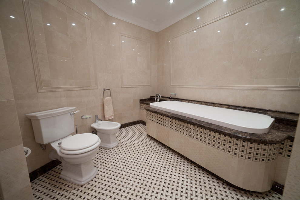 Ispirazione per una grande stanza da bagno padronale tradizionale con ante con riquadro incassato, ante beige, vasca sottopiano, piastrelle beige, piastrelle di marmo, pavimento in marmo, lavabo sottopiano e top in marmo