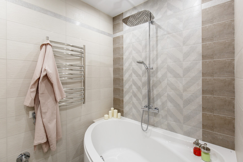 Cette photo montre une petite salle de bain principale tendance avec une baignoire d'angle, WC suspendus, un carrelage gris, des carreaux de céramique, un mur gris, un sol en carrelage de porcelaine, un lavabo encastré, un plan de toilette en surface solide et un sol gris.