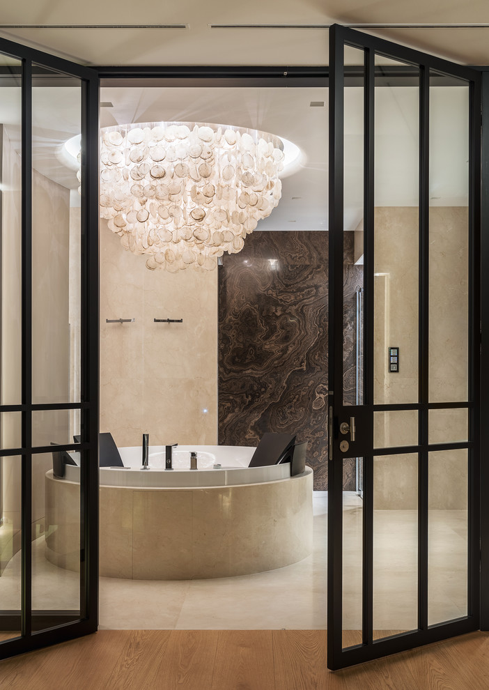 Стильный дизайн: большая главная ванная комната в современном стиле с отдельно стоящей ванной, бежевой плиткой, коричневой плиткой, мраморной плиткой, бежевыми стенами, мраморным полом и бежевым полом - последний тренд