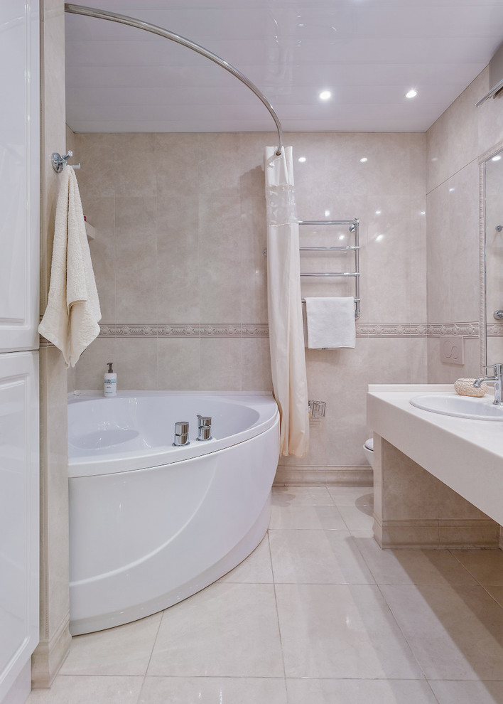 Traditional ensuite bathroom in Moscow with a corner bath, a shower/bath combination, beige tiles, beige walls and a built-in sink.
