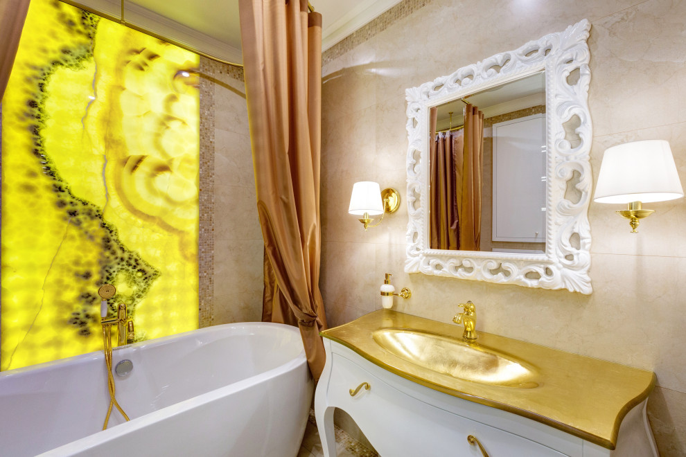 Пример оригинального дизайна: главная ванная комната среднего размера в стиле неоклассика (современная классика) с отдельно стоящей ванной, инсталляцией, бежевой плиткой, плиткой из листового камня, бежевыми стенами, полом из керамической плитки, стеклянной столешницей, бежевым полом, тумбой под одну раковину, напольной тумбой и панелями на стенах