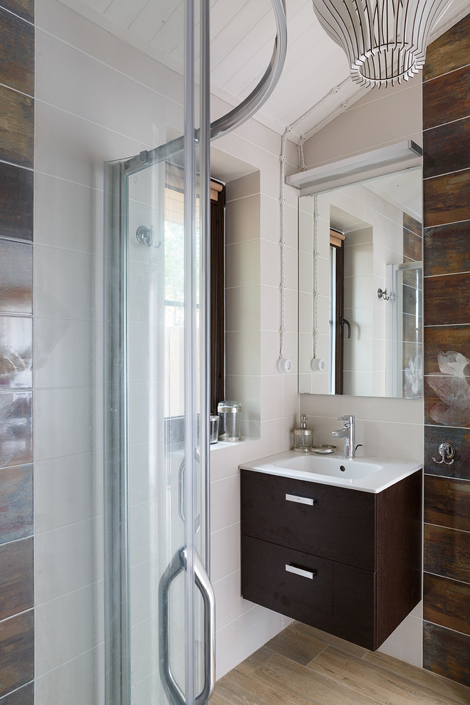 This is an example of a medium sized contemporary shower room bathroom in Saint Petersburg with a corner shower, a wall mounted toilet, multi-coloured tiles, ceramic tiles, multi-coloured walls, porcelain flooring, an integrated sink, brown floors and a sliding door.