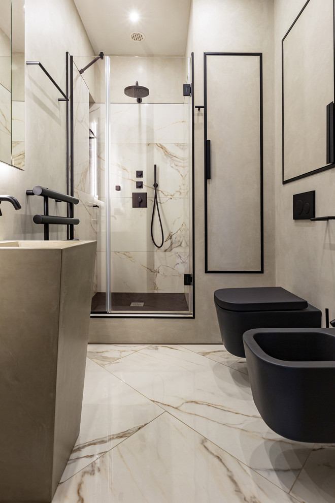 Idéer för små funkis grått badrum med dusch, med luckor med profilerade fronter, grå skåp, en dusch i en alkov, en bidé, grå kakel, porslinskakel, grå väggar, klinkergolv i porslin, ett piedestal handfat, bänkskiva i betong, beiget golv och dusch med gångjärnsdörr