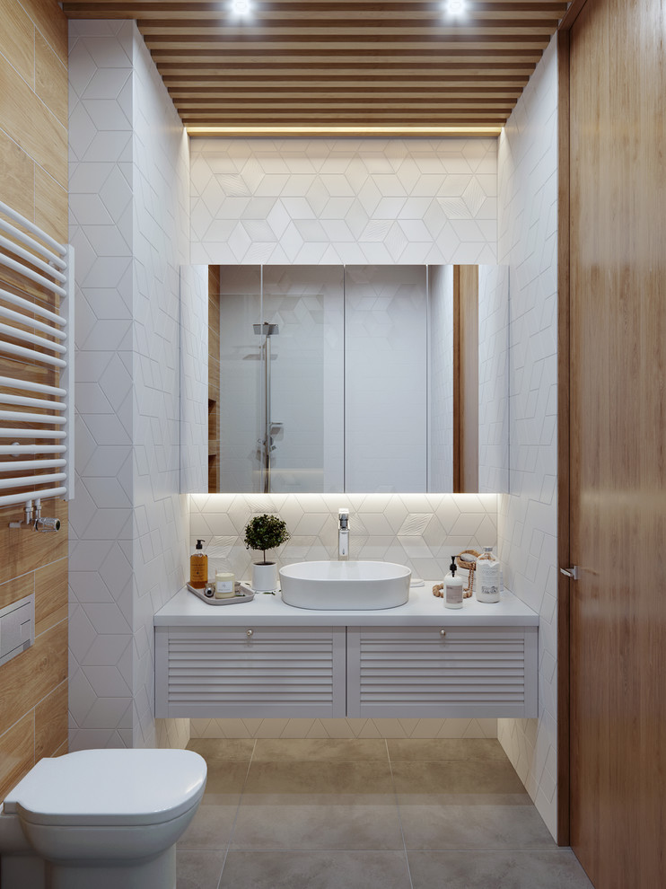 Идея дизайна: ванная комната среднего размера в современном стиле с фасадами с филенкой типа жалюзи, белыми фасадами, инсталляцией, белой плиткой, керамической плиткой, белыми стенами, полом из керамогранита, душевой кабиной, столешницей из искусственного камня, серым полом, белой столешницей и настольной раковиной
