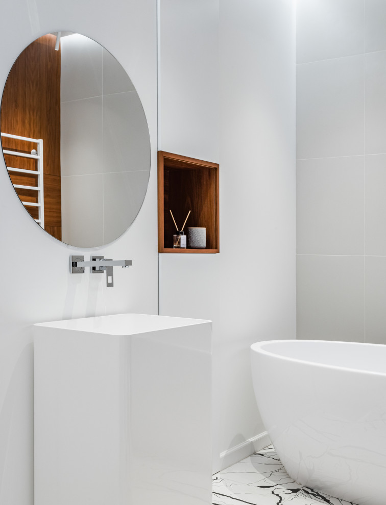 На фото: главная ванная комната в современном стиле с отдельно стоящей ванной, белой плиткой и тумбой под одну раковину с