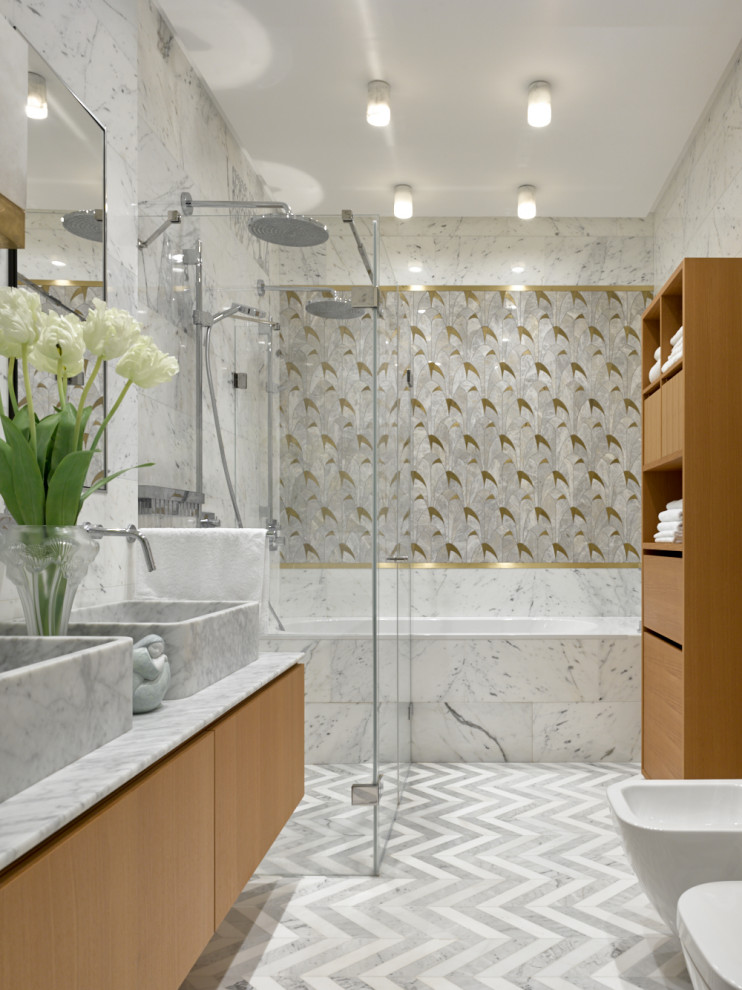Cette image montre une salle de bain design en bois brun avec un placard à porte plane, une baignoire en alcôve, une douche à l'italienne, une vasque, un plan de toilette blanc, un carrelage blanc, un sol gris et une cabine de douche à porte battante.