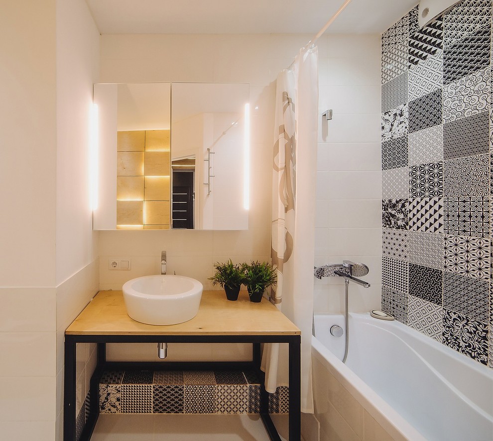 Источник вдохновения для домашнего уюта: ванная комната в современном стиле с ванной в нише, душем над ванной, черно-белой плиткой, белыми стенами, настольной раковиной, столешницей из дерева и бежевой столешницей