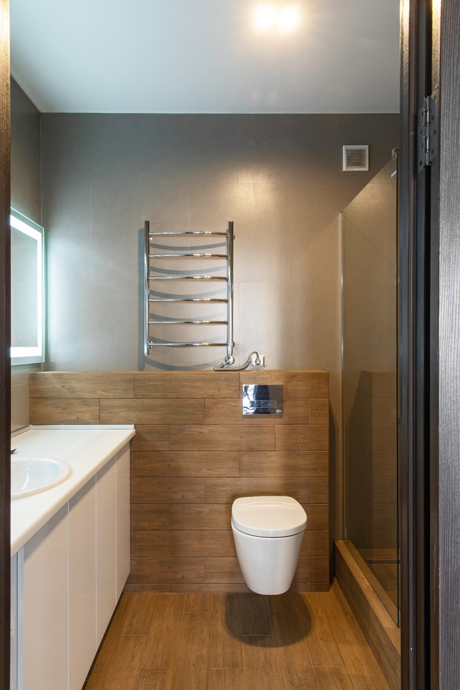 Ejemplo de cuarto de baño actual con puertas de armario blancas, sanitario de pared, aseo y ducha y lavabo encastrado