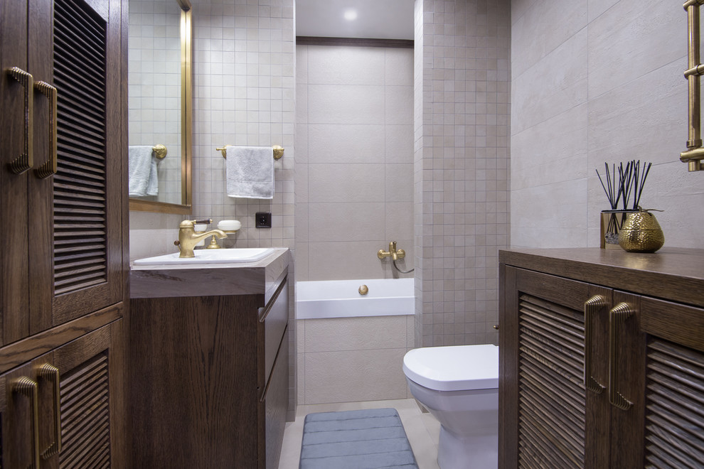 Стильный дизайн: главная ванная комната в современном стиле с плоскими фасадами, темными деревянными фасадами, ванной в нише, душем над ванной, раздельным унитазом, серой плиткой и накладной раковиной - последний тренд