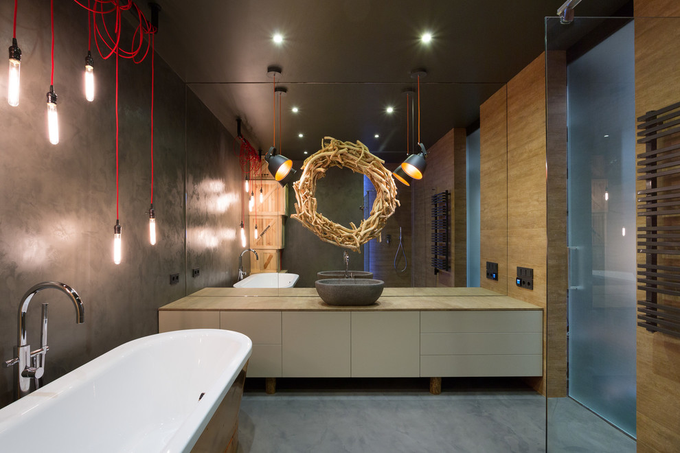 Industrial Badezimmer mit Aufsatzwaschbecken, flächenbündigen Schrankfronten, beigen Schränken, freistehender Badewanne, bodengleicher Dusche und grauer Wandfarbe in Sonstige