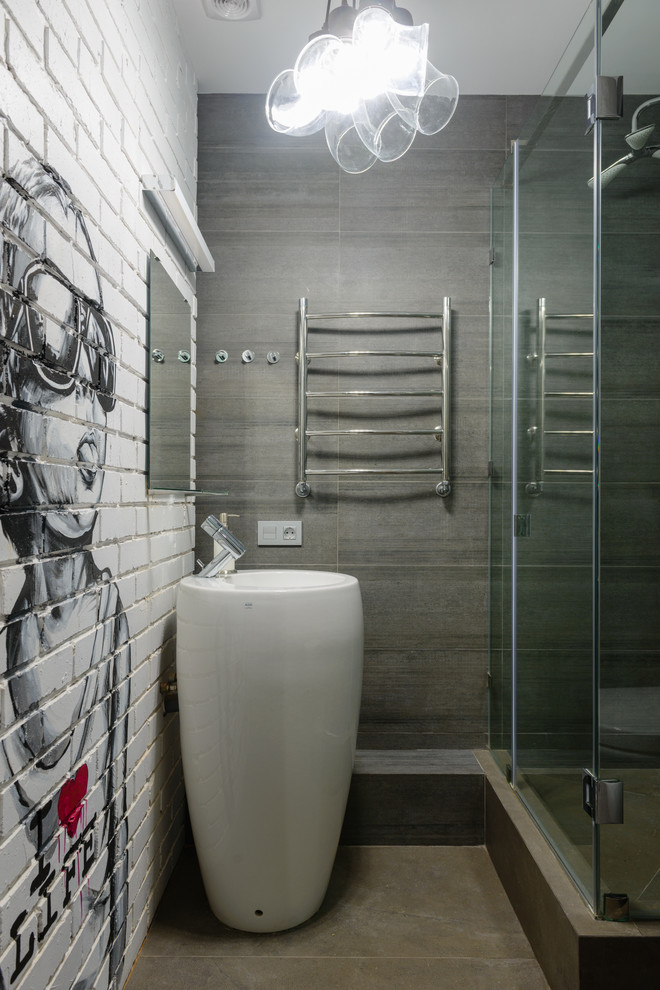 Modelo de cuarto de baño industrial con paredes grises y lavabo con pedestal