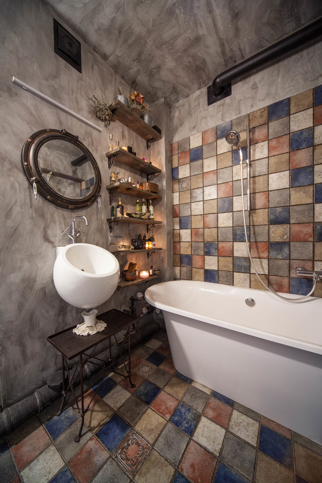 Foto på ett litet industriellt en-suite badrum, med ett fristående badkar, en dusch/badkar-kombination, flerfärgad kakel, keramikplattor, grå väggar, klinkergolv i keramik, ett väggmonterat handfat och flerfärgat golv