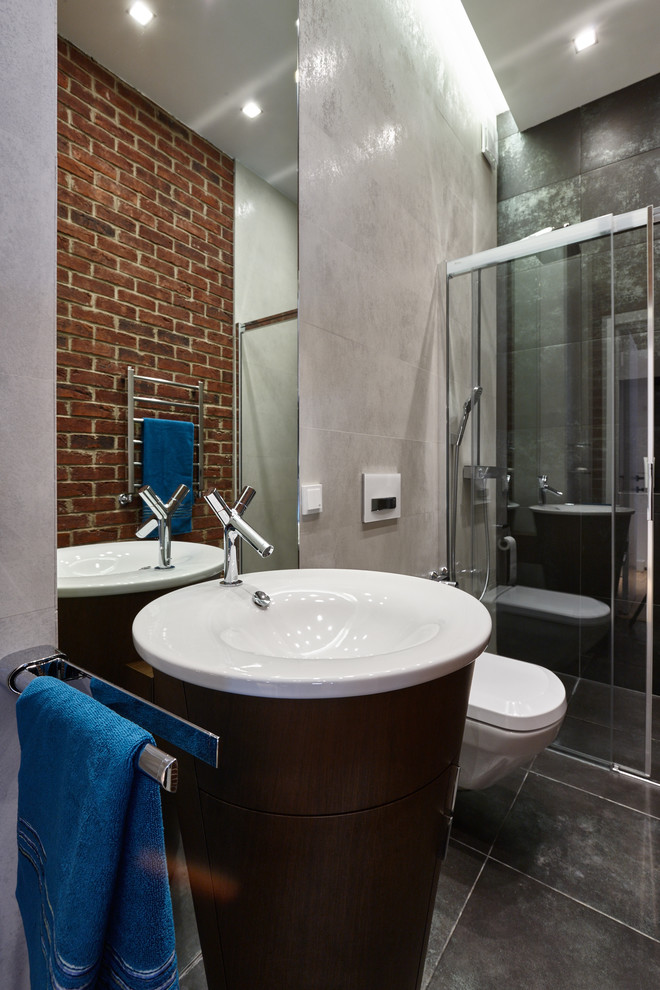 На фото: ванная комната среднего размера в стиле лофт с душем в нише, инсталляцией, керамогранитной плиткой, полом из керамогранита, черным полом, душем с раздвижными дверями, серой плиткой, серыми стенами, душевой кабиной и монолитной раковиной