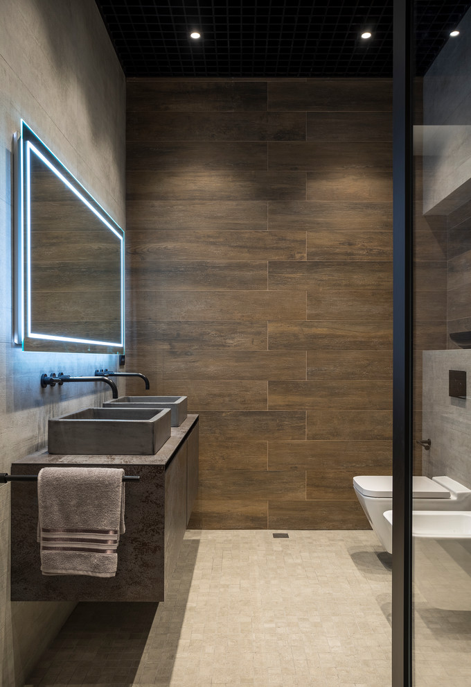 На фото: ванная комната в стиле лофт с плоскими фасадами, серыми фасадами, писсуаром, коричневой плиткой, настольной раковиной, бежевым полом и серой столешницей с