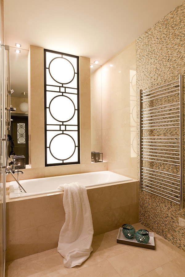 Пример оригинального дизайна: главная ванная комната среднего размера в современном стиле с ванной в нише, бежевой плиткой, каменной плиткой, бежевыми стенами, мраморным полом, мраморной столешницей и душем над ванной