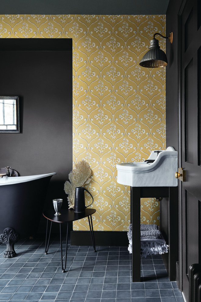 Идея дизайна: главная ванная комната в стиле неоклассика (современная классика) с ванной на ножках, желтыми стенами, консольной раковиной и черным полом