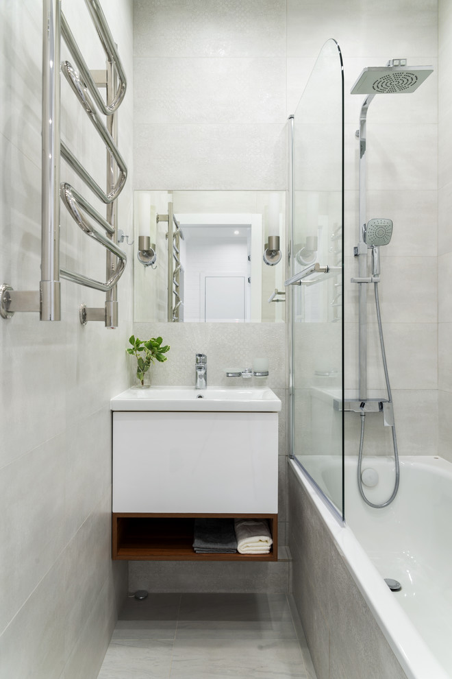 Ejemplo de cuarto de baño principal contemporáneo con armarios con paneles lisos, puertas de armario blancas, bañera empotrada, combinación de ducha y bañera, baldosas y/o azulejos grises, lavabo integrado y suelo gris
