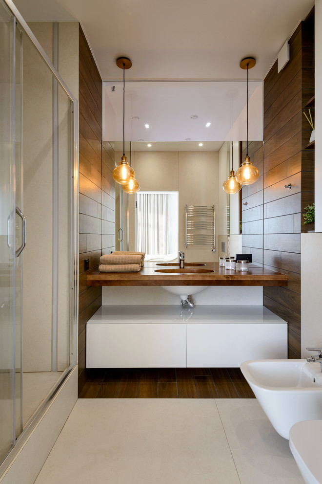 Пример оригинального дизайна: ванная комната в современном стиле с плоскими фасадами, белыми фасадами, душем в нише, биде, душевой кабиной, врезной раковиной, бежевым полом, душем с раздвижными дверями и коричневой столешницей