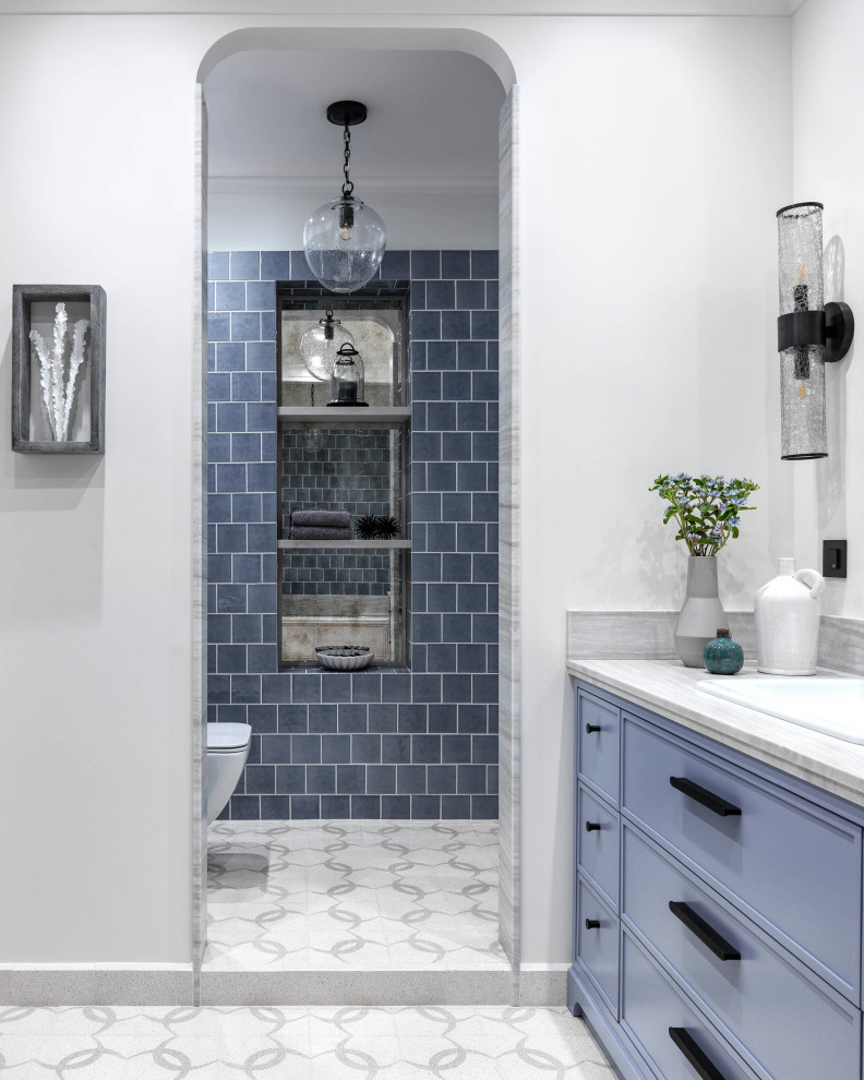 Источник вдохновения для домашнего уюта: главная ванная комната среднего размера в современном стиле с фасадами с утопленной филенкой, синими фасадами, ванной в нише, душевой комнатой, инсталляцией, синей плиткой, плиткой кабанчик, белыми стенами, полом из цементной плитки, накладной раковиной, мраморной столешницей, белым полом, душем с распашными дверями и серой столешницей